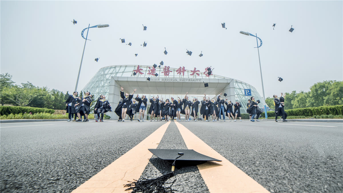 Graduating students celebrating at the Dalian Medical University main entrance