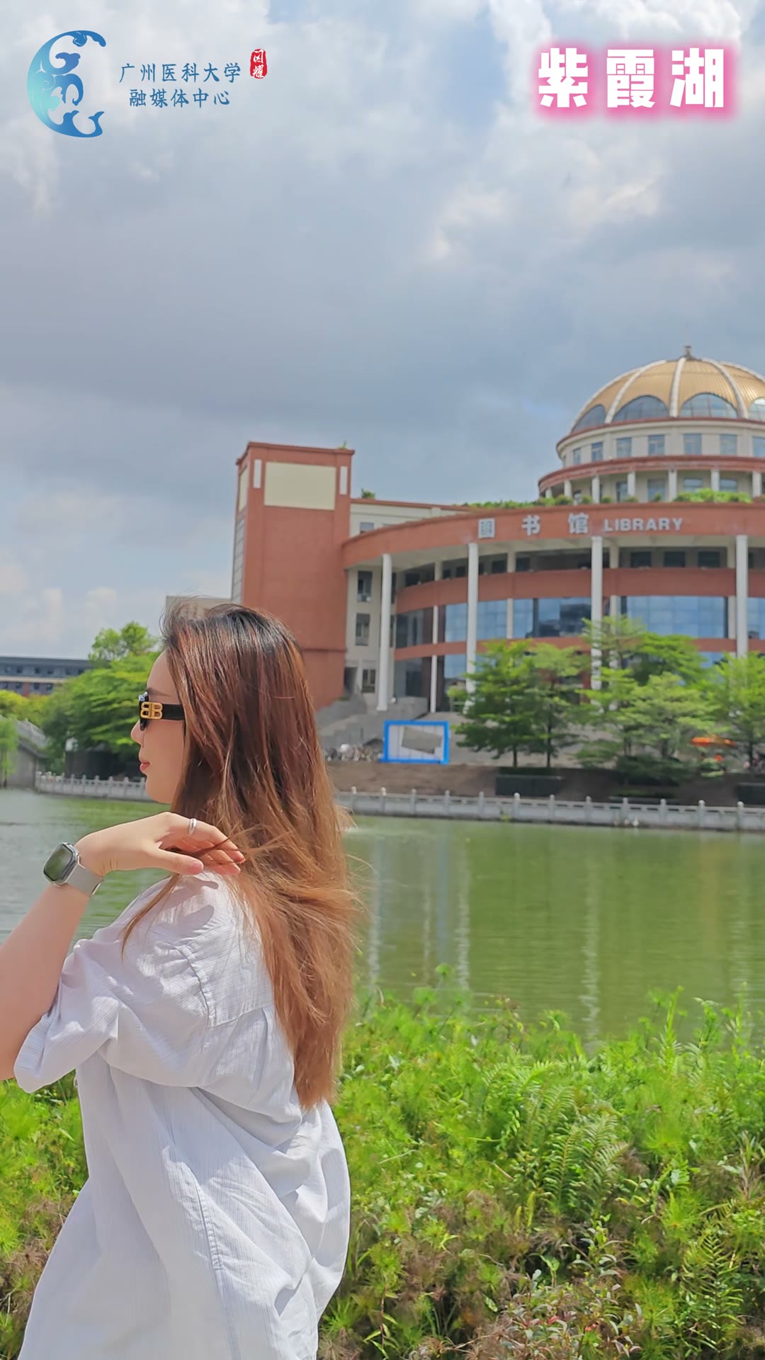 Student beside Qingshui Lake with Guangzhou Medical University library in the background