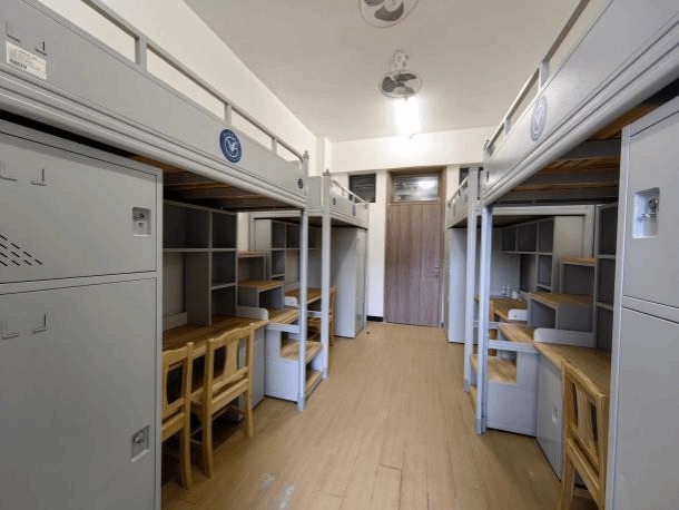 Four-student dormitory room with beds desks and storage at Guangzhou Medical University