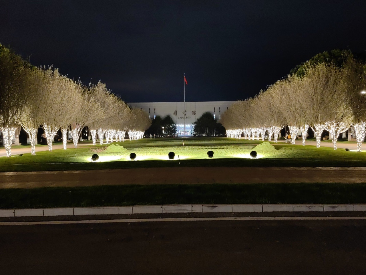 Illuminated avenue leading to Kunming Medical University Library at night