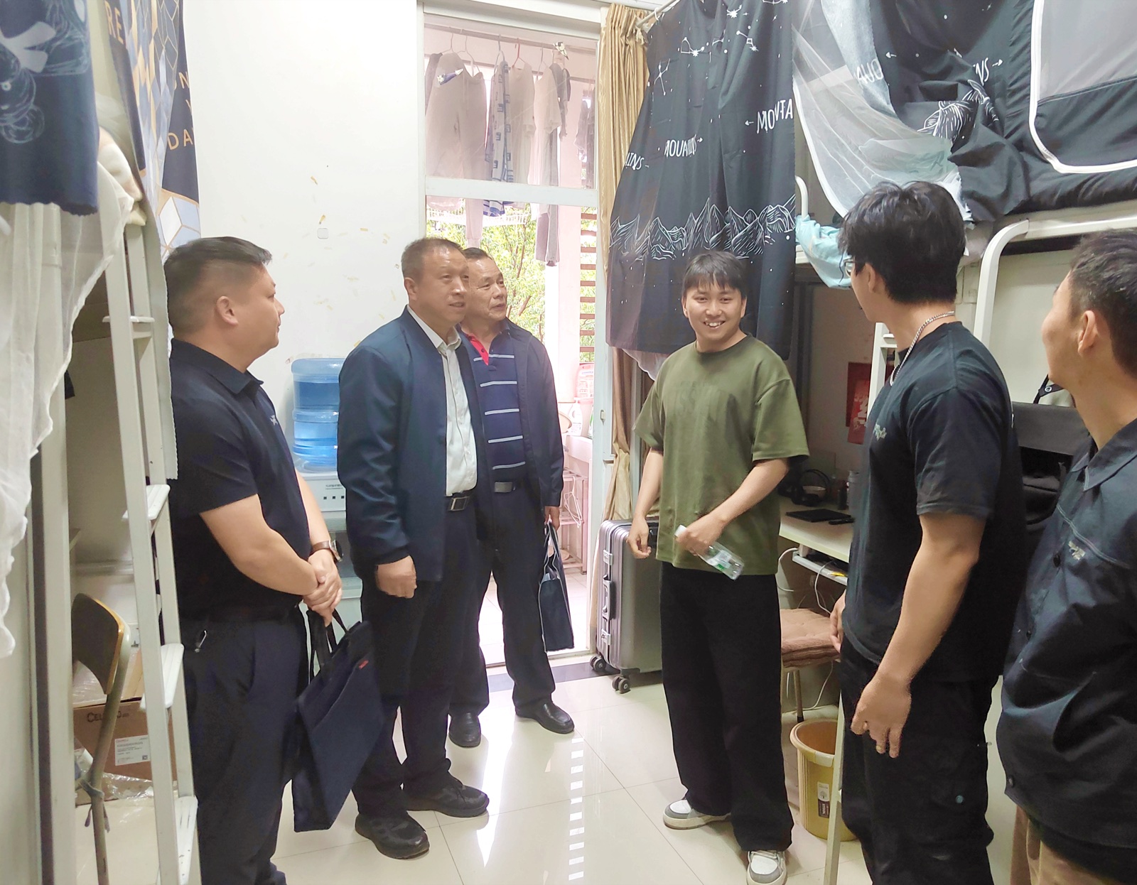 Student and university staff inside a Kunming Medical University dormitory room