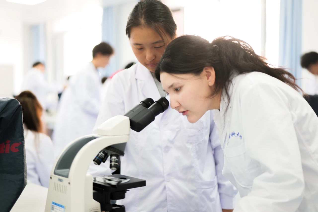 Medical students using a microscope in a Xinjiang Medical University laboratory