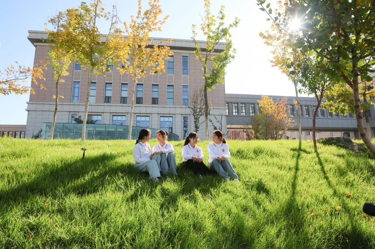 Students sitting on the lawn at Xinjiang Medical University Xuelianshan Campus